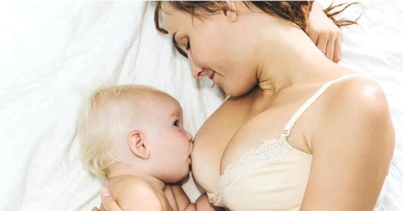 Baby und eine hilfreiche Erwachsenenhand