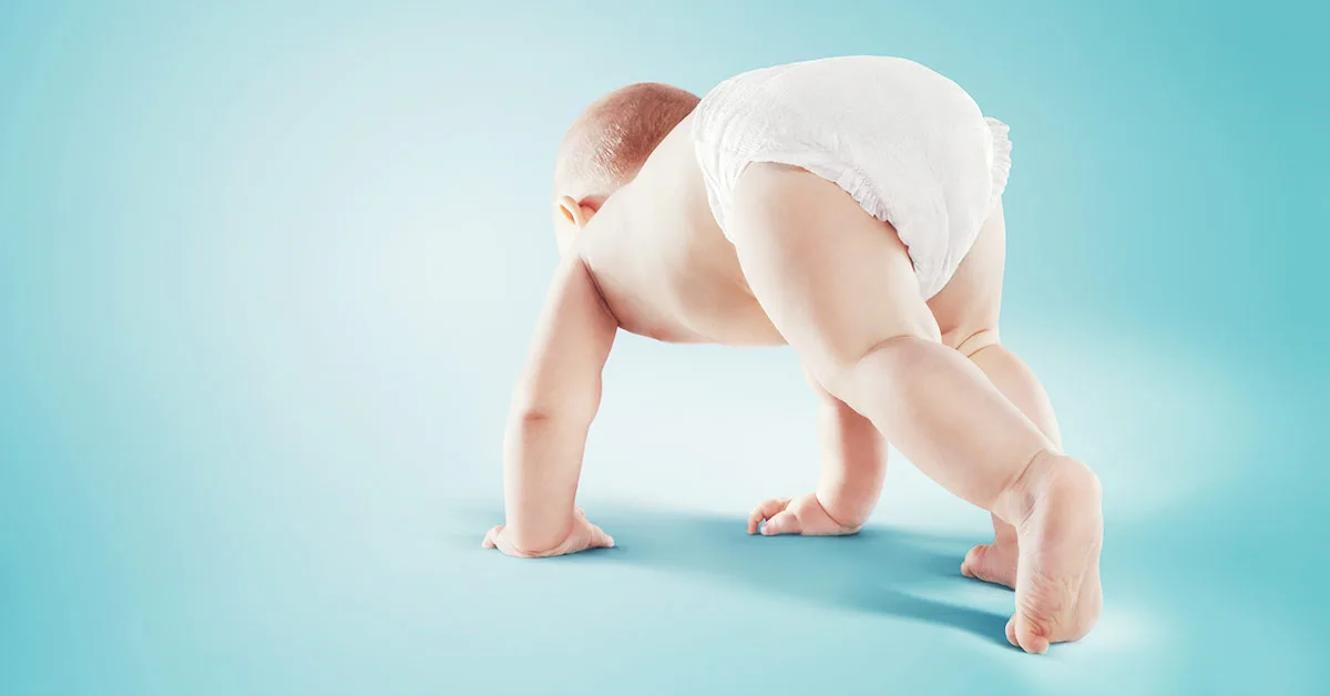 Baby mit einer Windel in der Startposition eines Läufers