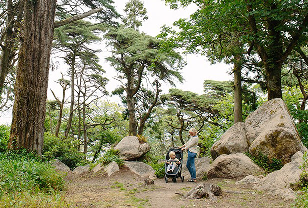 Mutter mit Kinderwagen und Baby im Wald