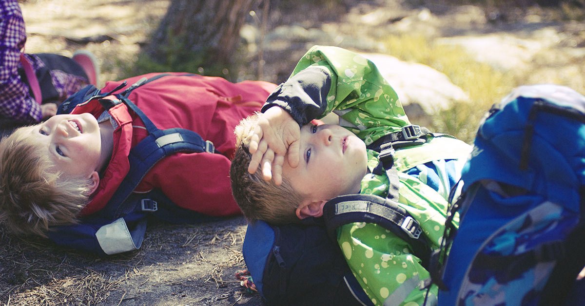 Kindheit Filmstill - 2 Jungen liegen am Rücken im Wald und schauen in die Sonne
