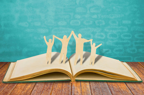 Seminare und Fortbildungen - Familie als Scherenschnitt auf einem geöffneten Buch